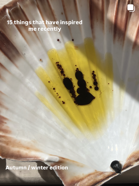 A close-up photograph of a seashell with oil and black pepper on its interior, with text overlay reading '15 things that have inspired me recently' and 'Autumn / winter edition'.