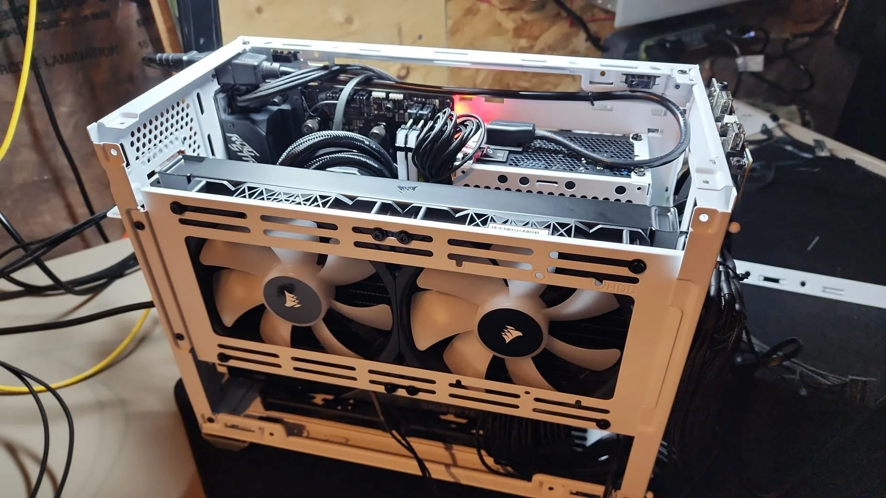 Open computer case with visible internal components, including cooling fans, power supply, and cables.