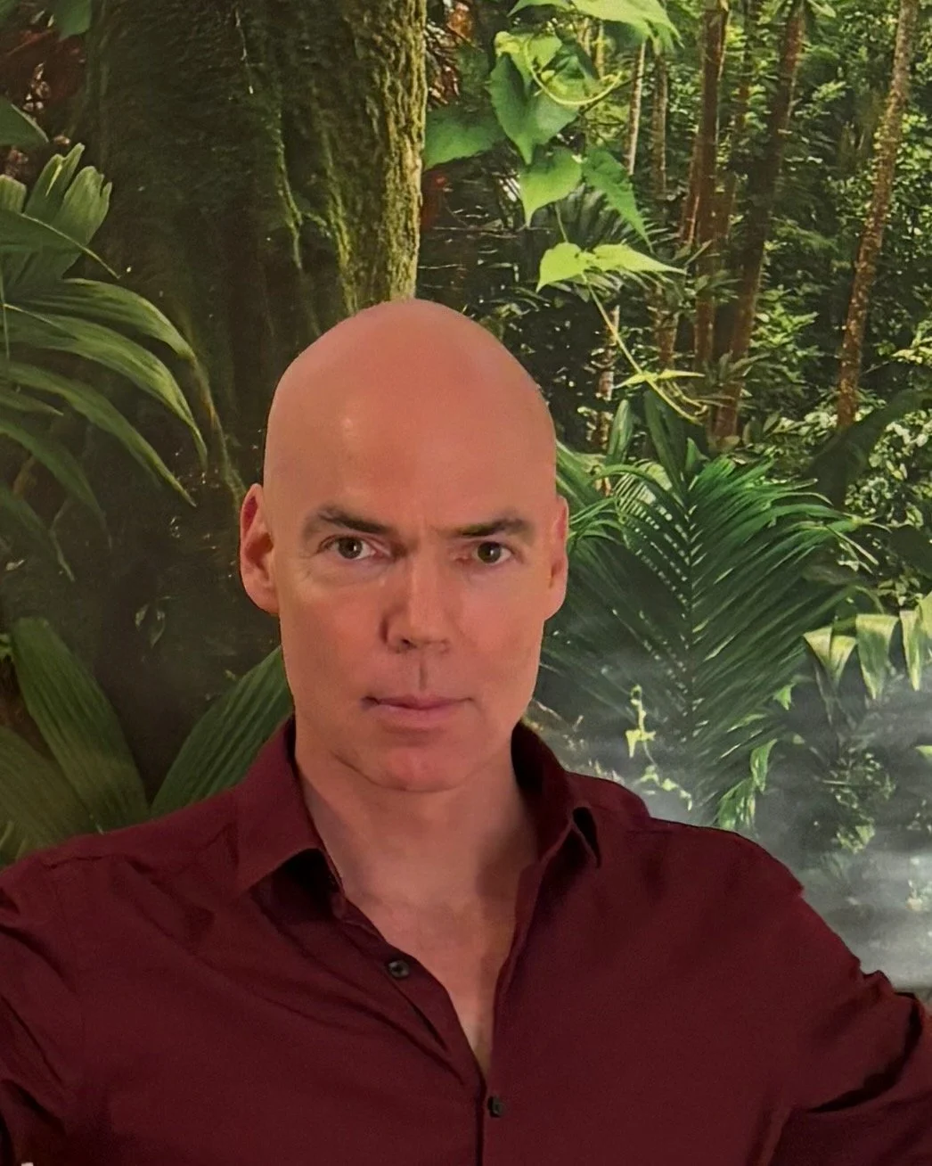 Portrait of Jörg Böttcher, psychologist from Berlin, in front of green leaves