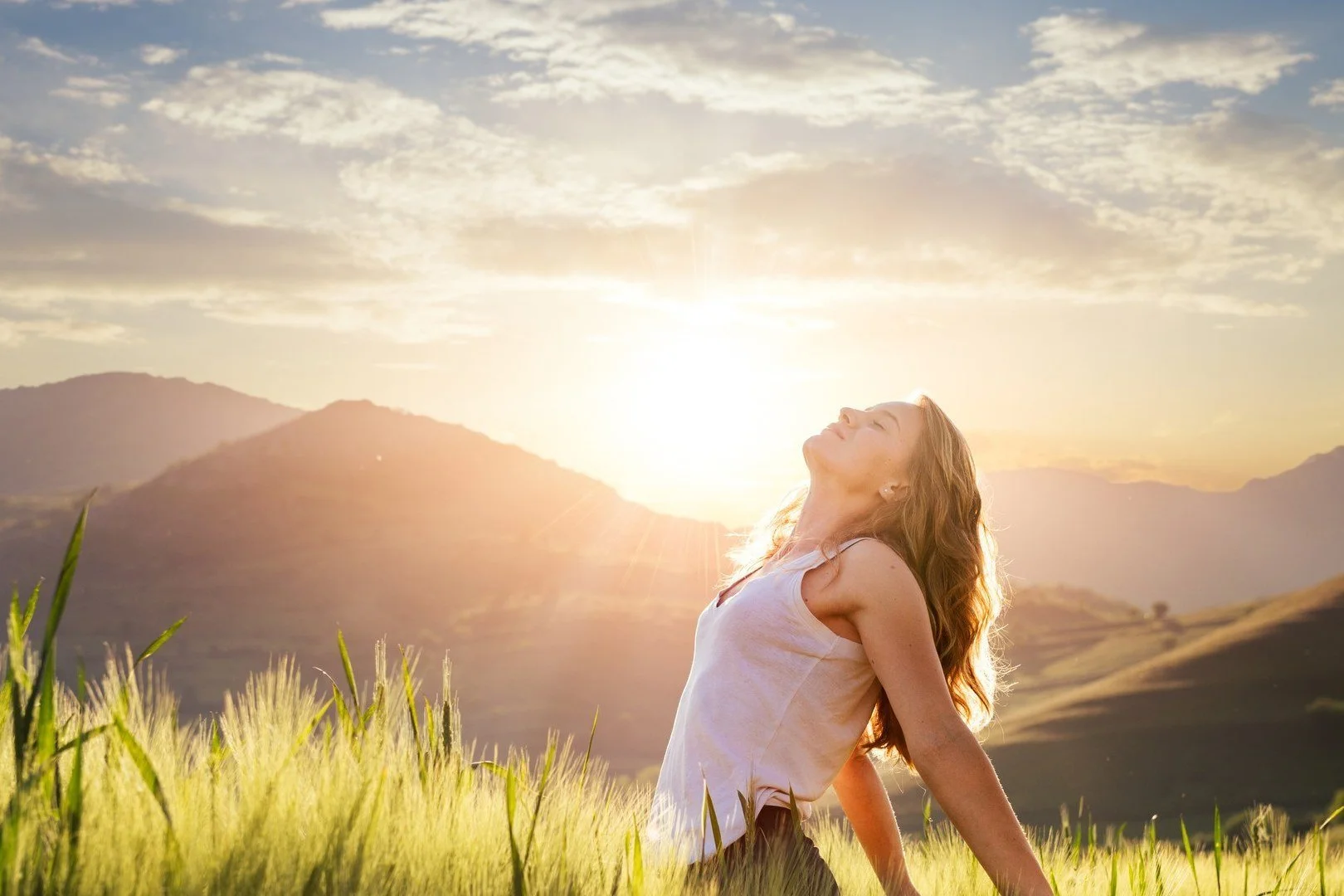 Woman breathing freely in a meadow at sunrise, Part One of the free stop smoking hypnosis audio