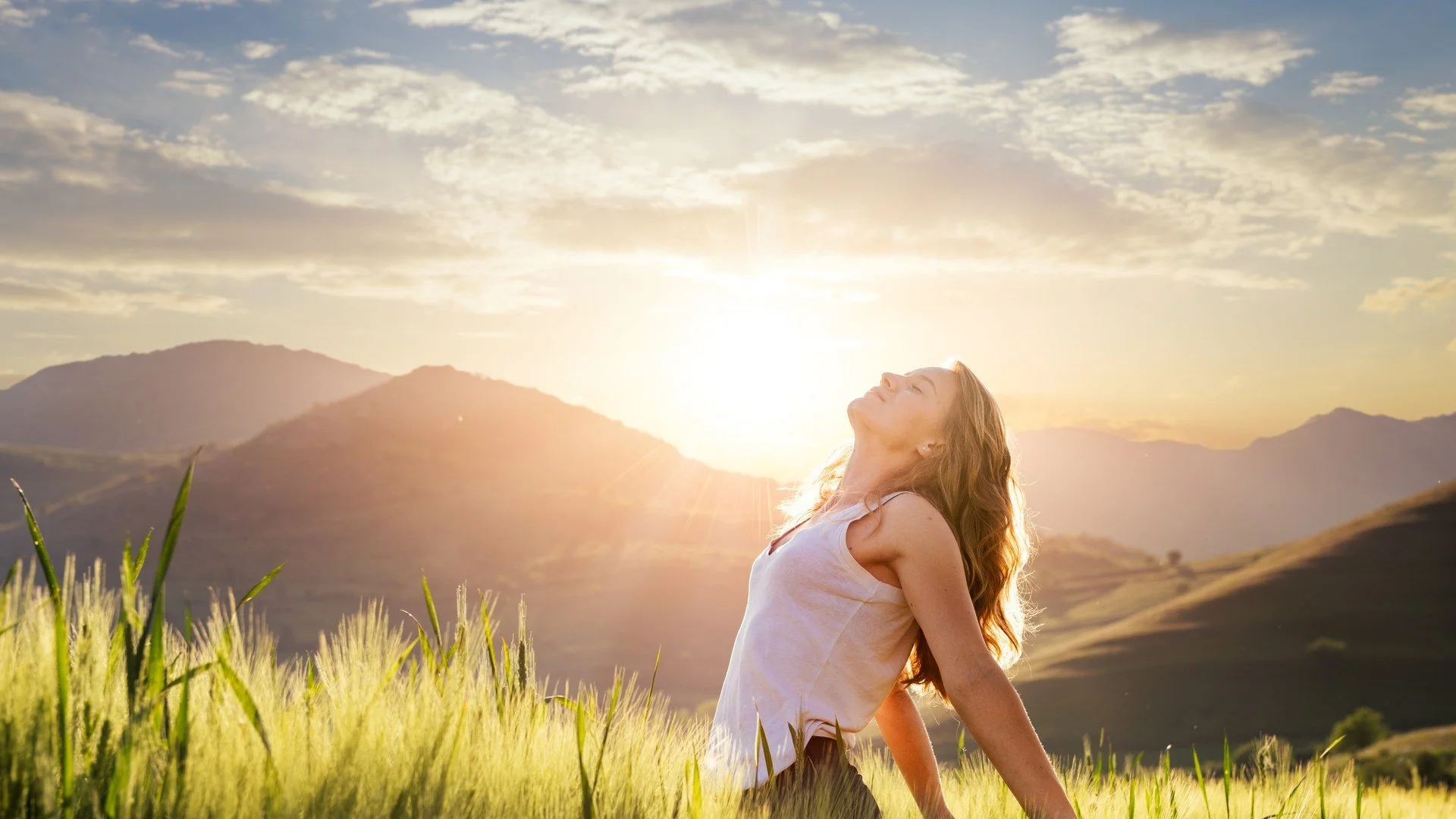 Woman breathing freely in a meadow at sunrise, quitting smoking without willpower