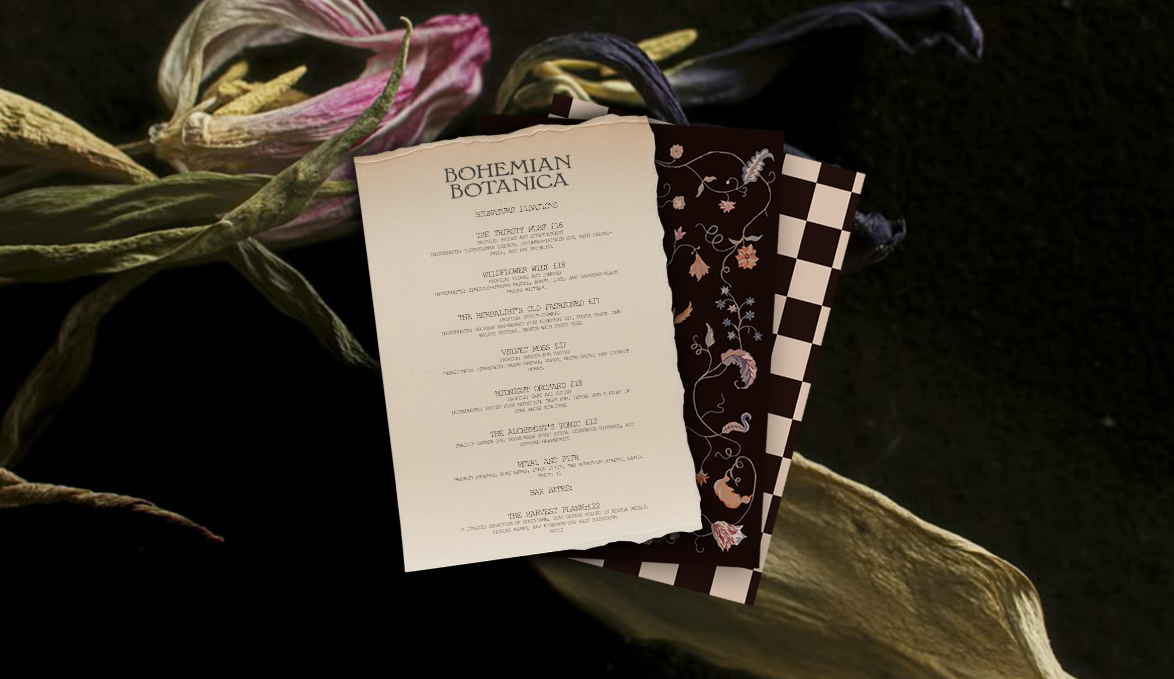 A printed menu titled 'Bohemian Botanica' on a dark surface, with layered decorative papers or cards underneath, and dried flowers or plant elements nearby.