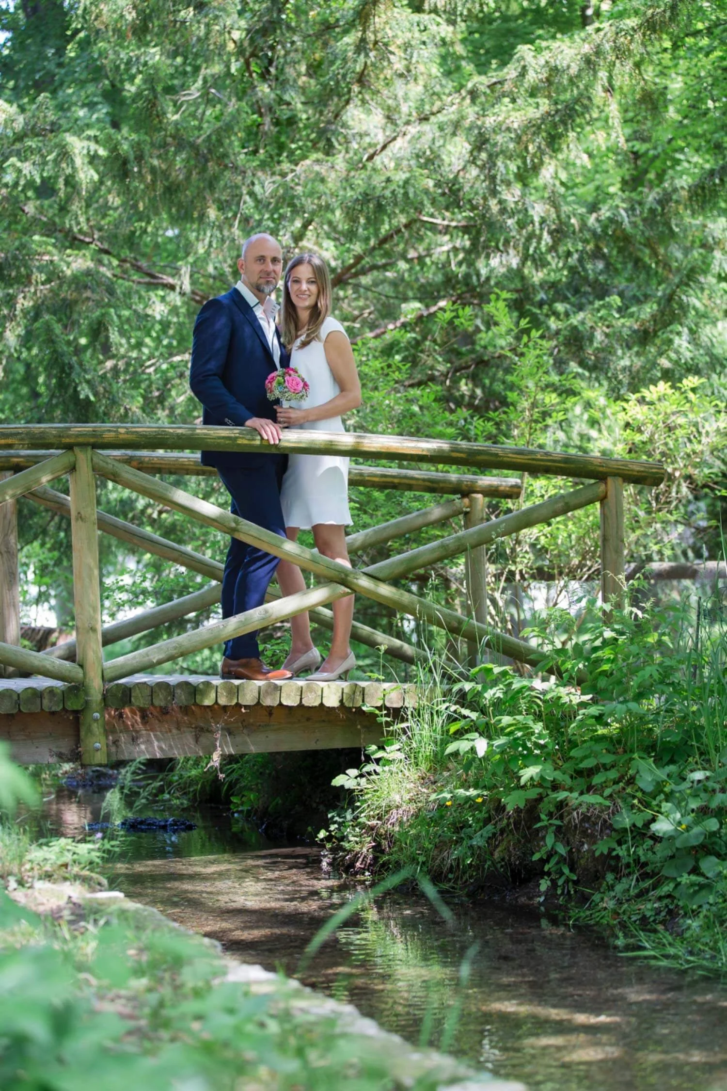 Wedding-couple-standing-close-on-bridge-in-park.jpg