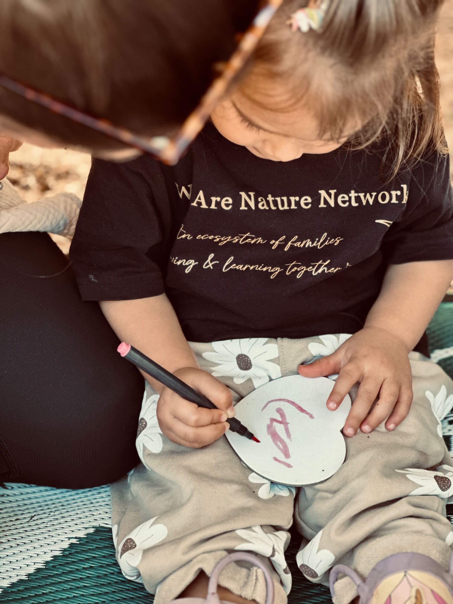 We-are-nature-girl-painting-on-heart-wearing-a-we-are-nature-t-shirt.jpg