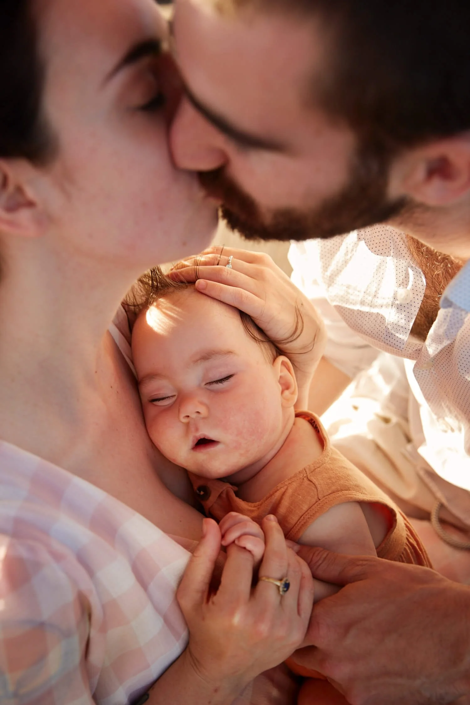 Family-Erin-kissing-holding-their-sleeping-Baby-in-the-arms.jpg