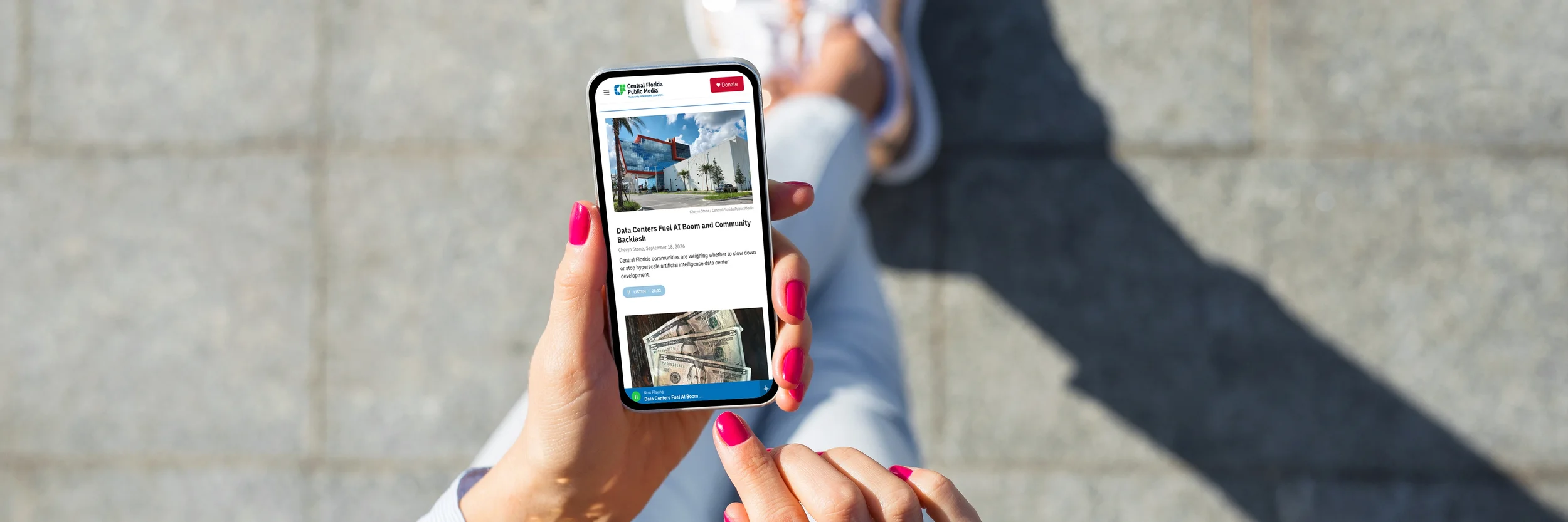 Person with pink nails holding a smartphone, viewing a news article on Central Florida Public Media's website about data centers and AI.