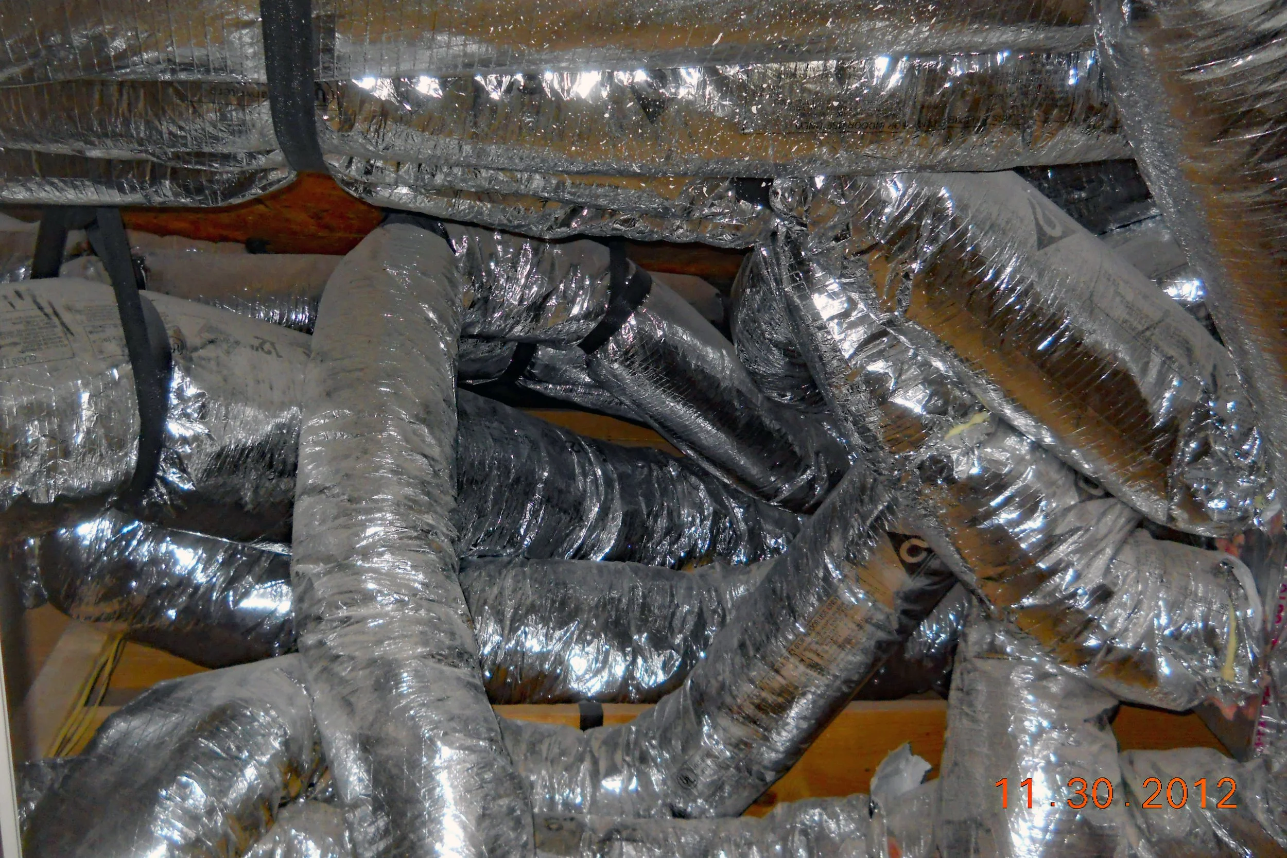 A large intersection of several heating venting and air conditioning flexible ducts in a house attic space found during a home inspection.