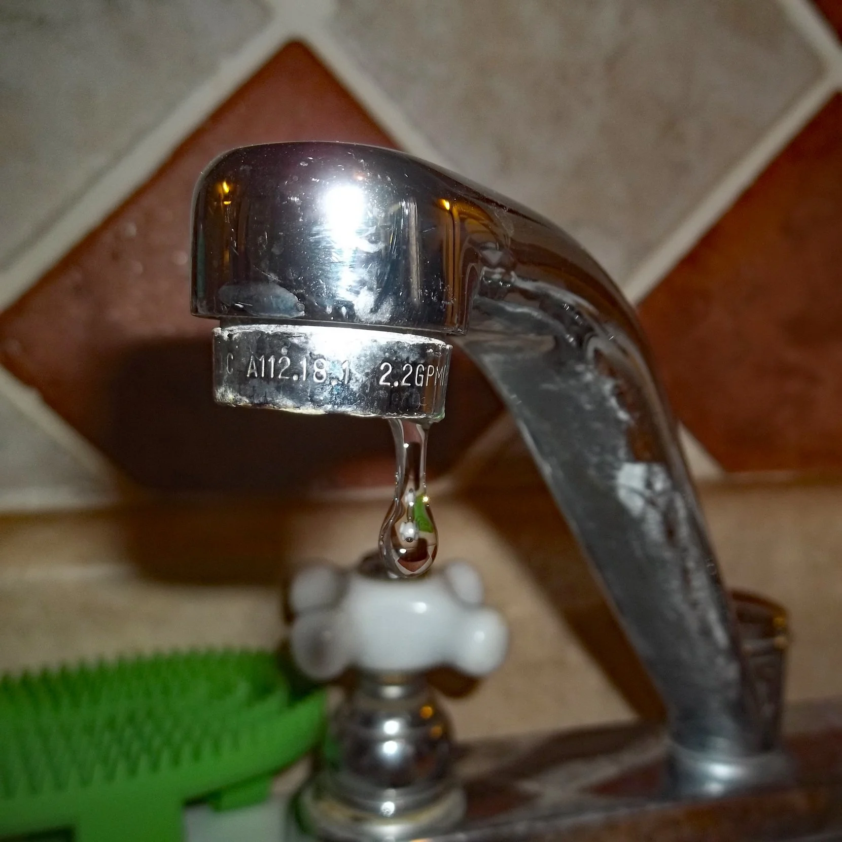 Kitchen sink water faucet with a constant dripping water leak found during a home inspection.