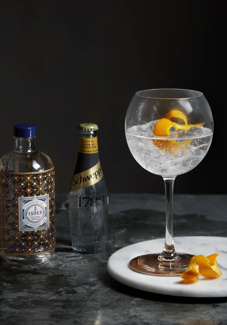 Styled drinks photography featuring Fishers Gin and Schweppes tonic with a gin and tonic on dark marble