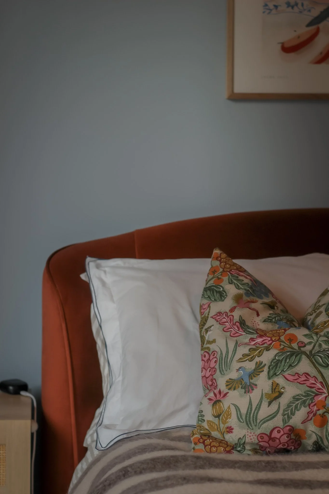 Bedroom interior design in Hackney, London, with an upholstered headboard, layered textiles and 70s-inspired details