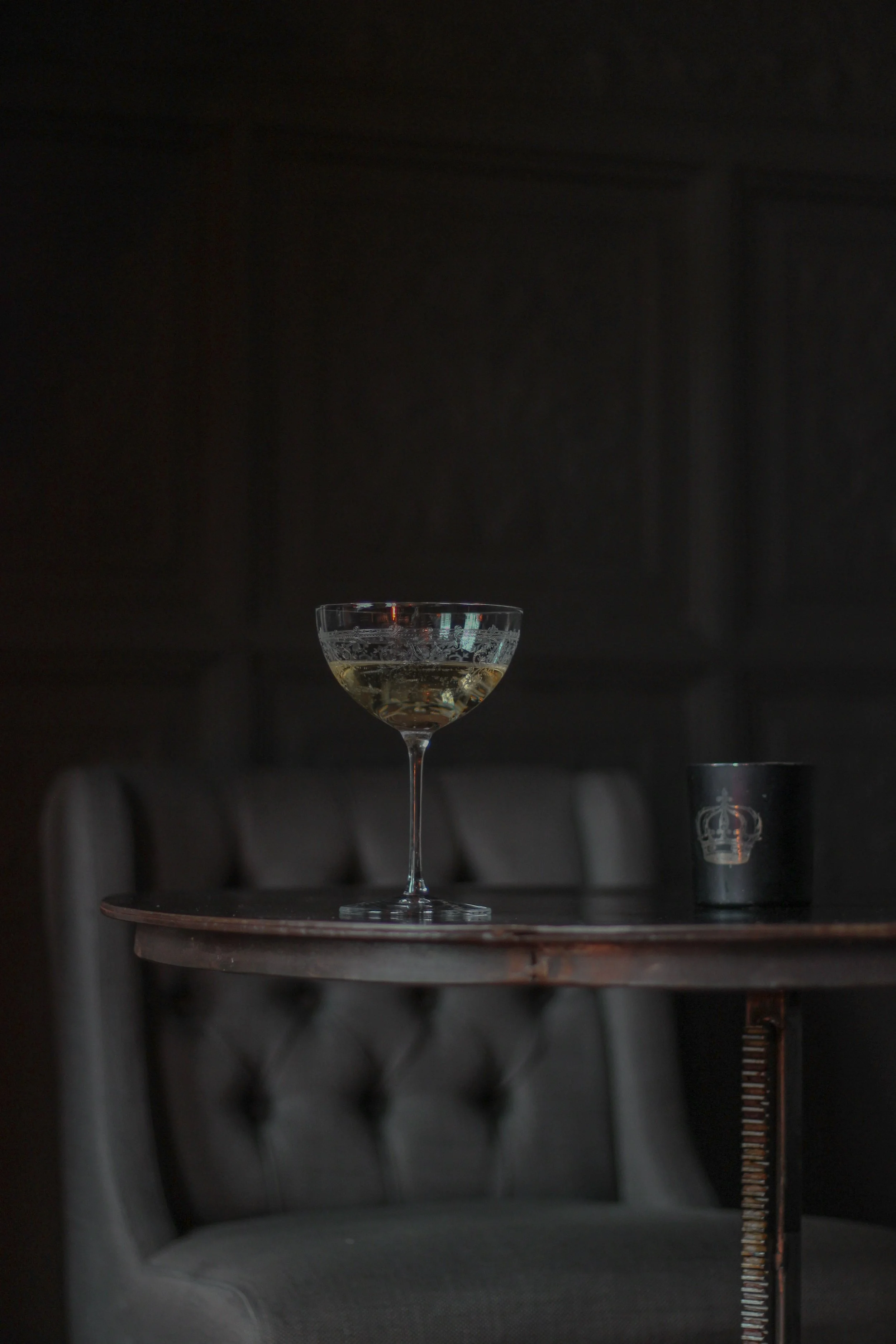 Hospitality photography for a boutique hotel in Bruges, Belgium, featuring an intimate cocktail setting with atmospheric lighting and coupe of champagne