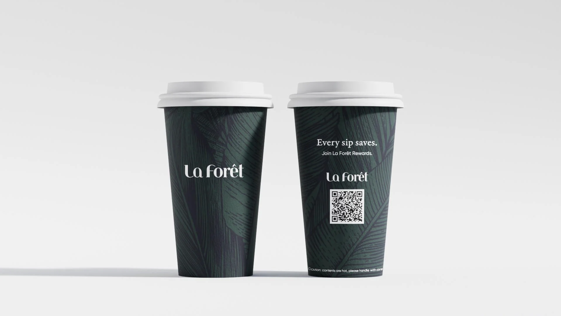 Two dark green to-go coffee cups with white lids set against a gray background. The cups have a leaf pattern and the brand name "La Forêt" printed on them, with one cup displaying a QR code and promotional text.
