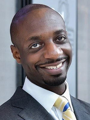 Close-up of a smiling man in a suit and tie.