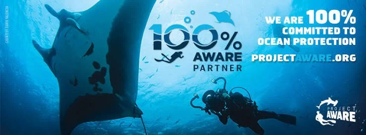 100% AWARE Partner banner featuring a large manta ray and scuba diver underwater, supporting ocean protection with Project AWARE