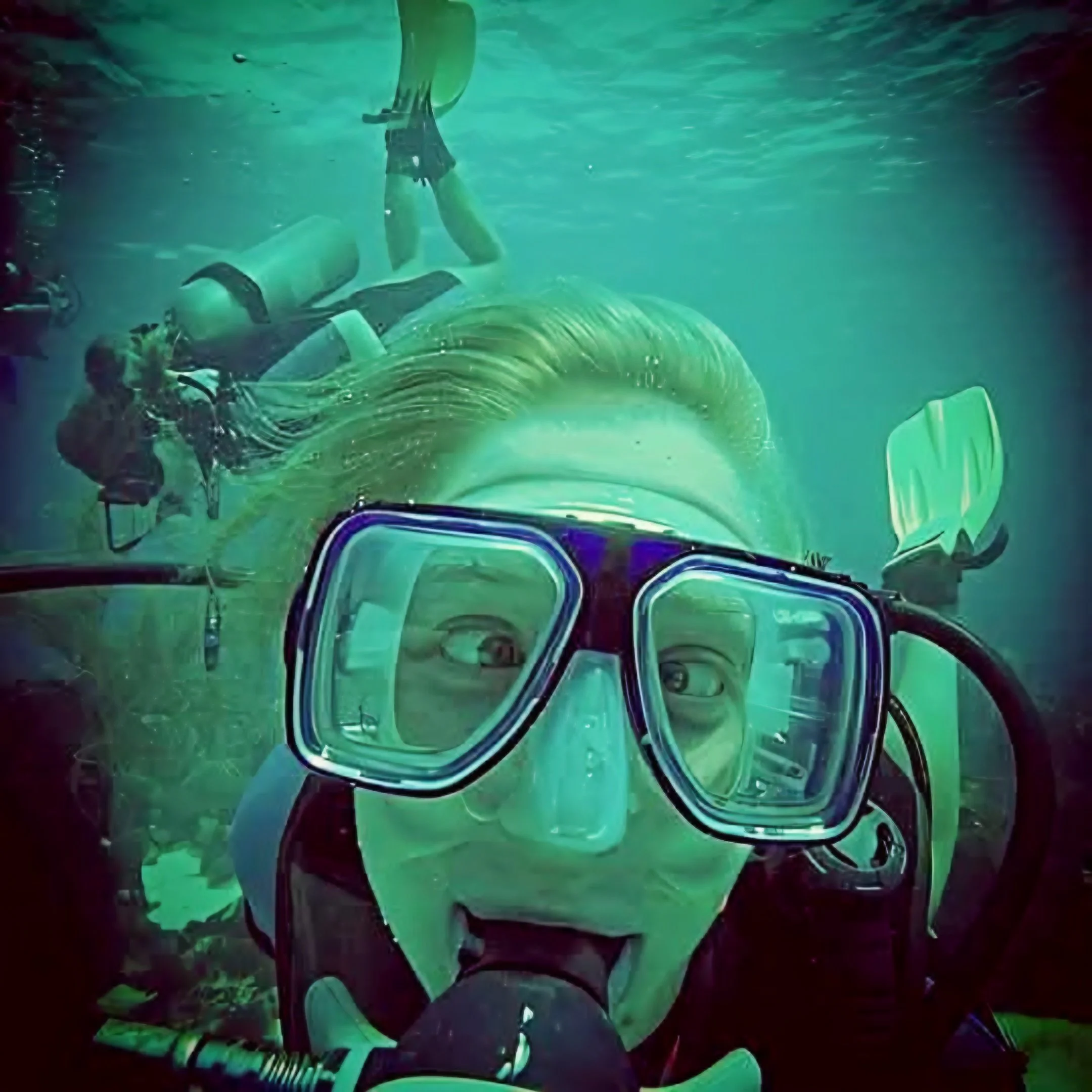 Underwater view of a bike submerged in water with bright colors reflecting off the surface.