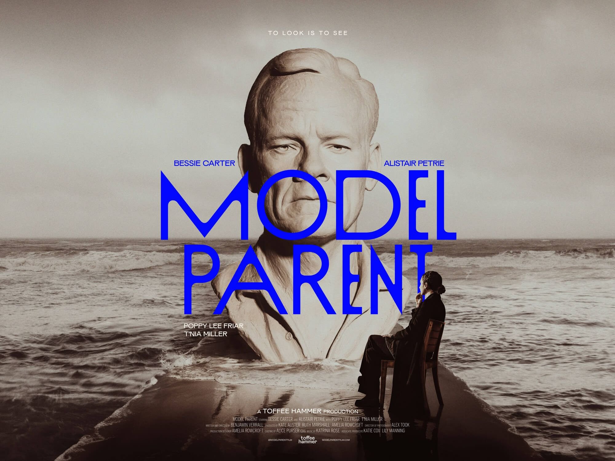 Poster for Model Parent, featuring a monumental sculpted head beside the sea.