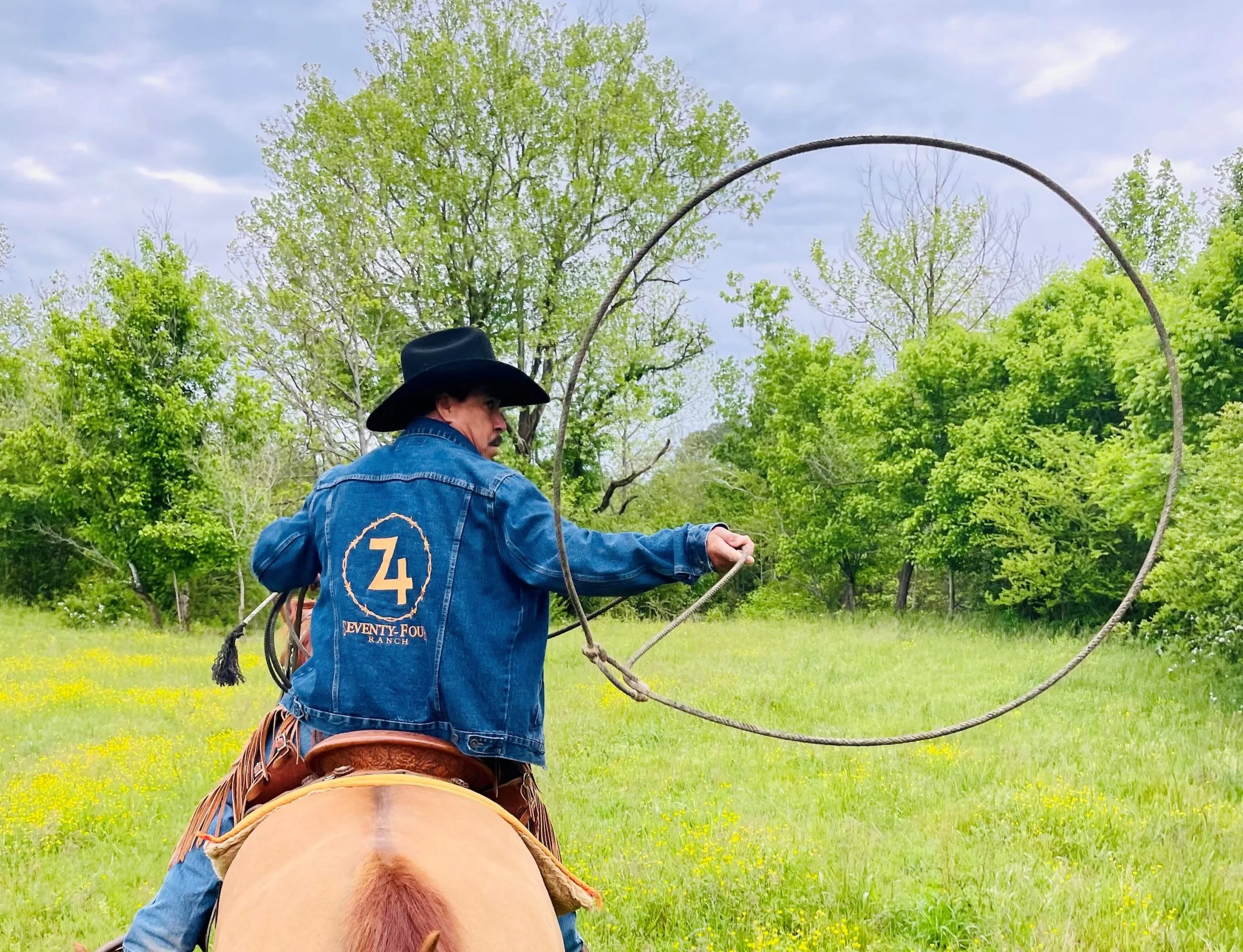 A Seventy-Four Ranch cowboy demonstrating roping from horseback