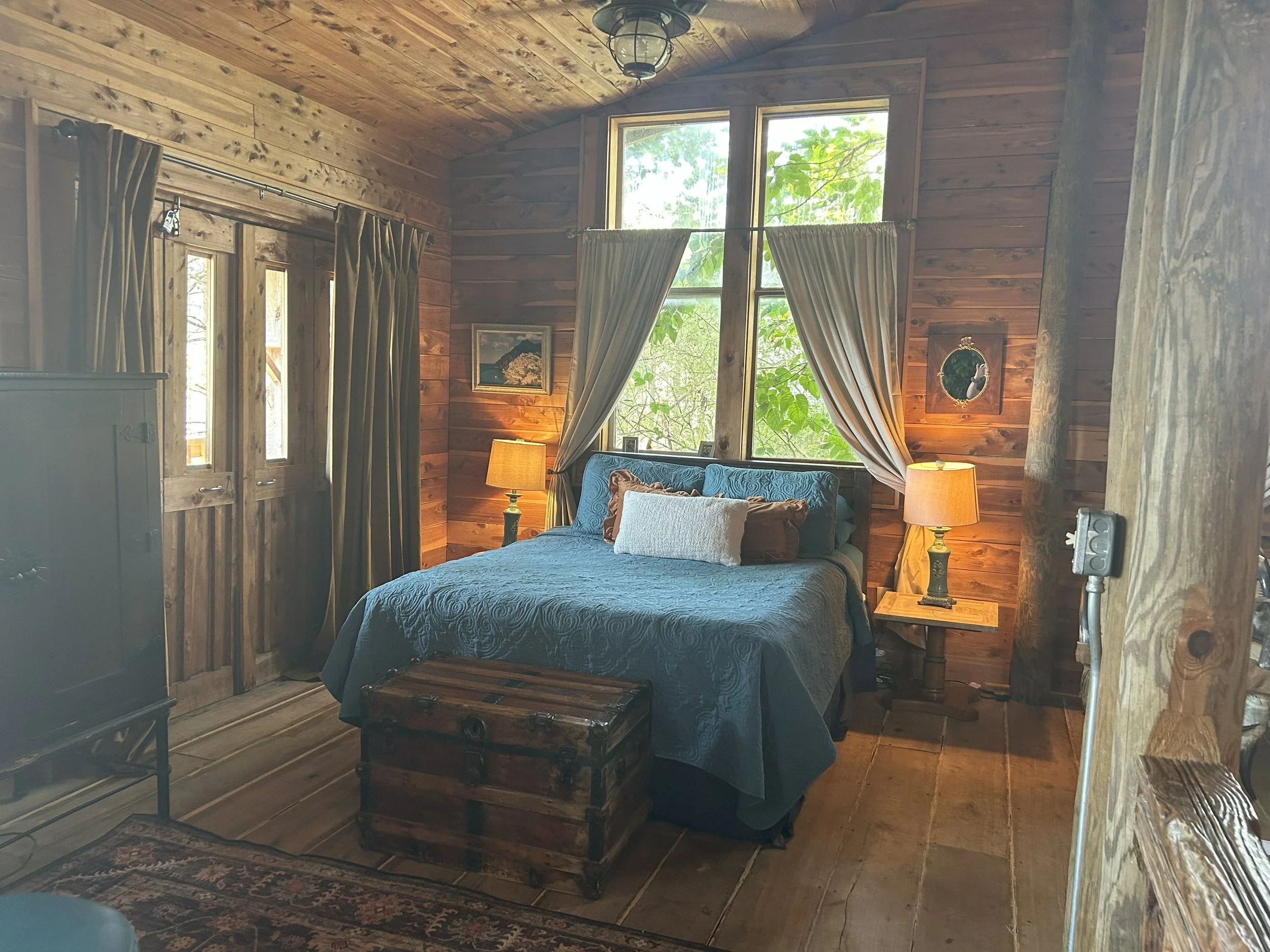 The Overlook guest room at Seventy-Four Ranch, with a blue bed and warm wood interior