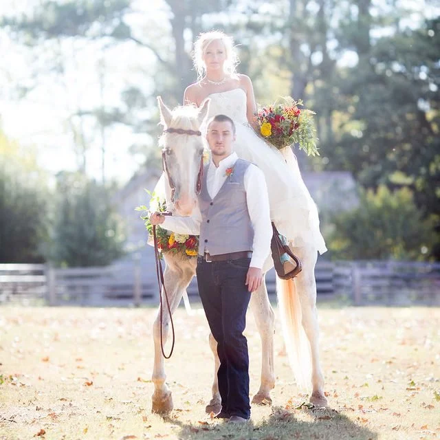 A bride and groom with a horse at Seventy-Four Ranch
