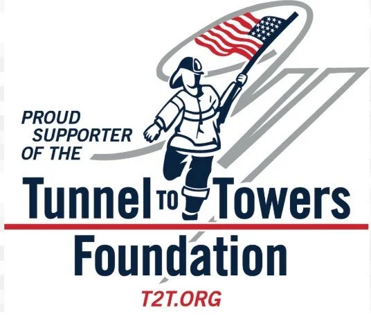 A firefighter holding an American flag with text that reads "Proud supporter of the Tunnel to Towers Foundation" and the website T2T.ORG.