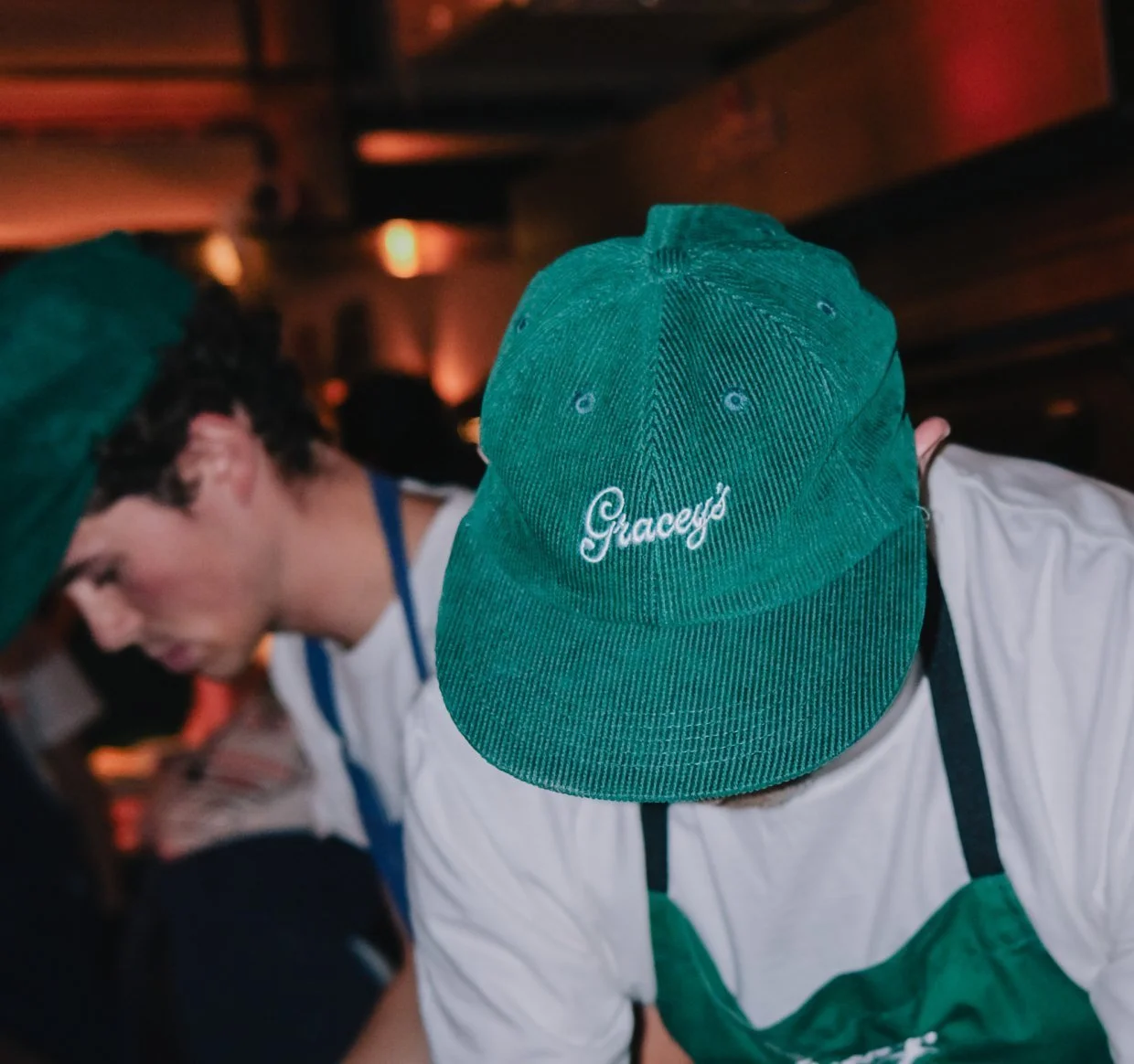 Gracey’s Pizza staff member wearing the green Gracey’s cord cap
