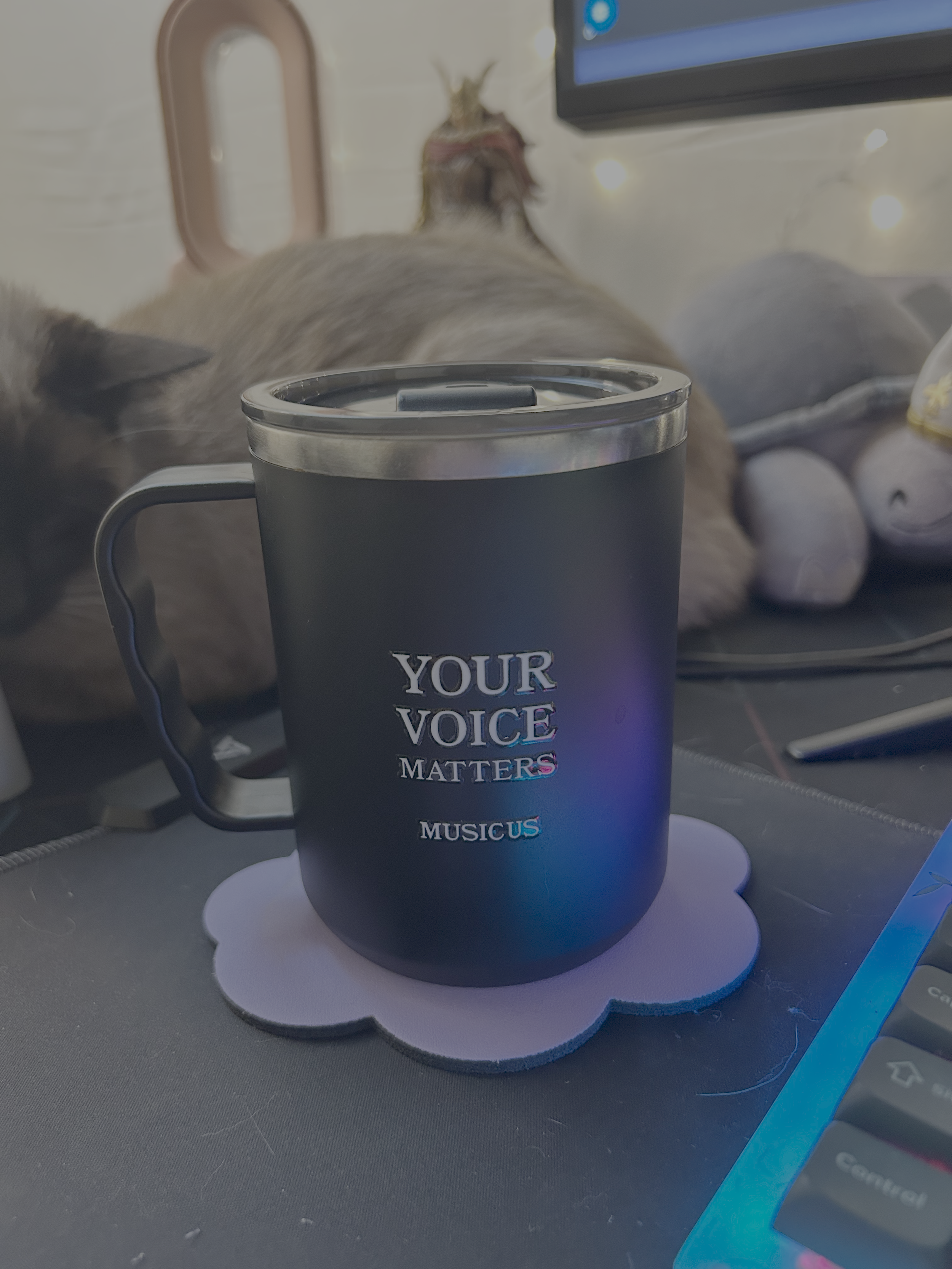 A black coffee mug with the words 'YOUR VOICE MATTERS' printed on it, placed on a white paper coaster.