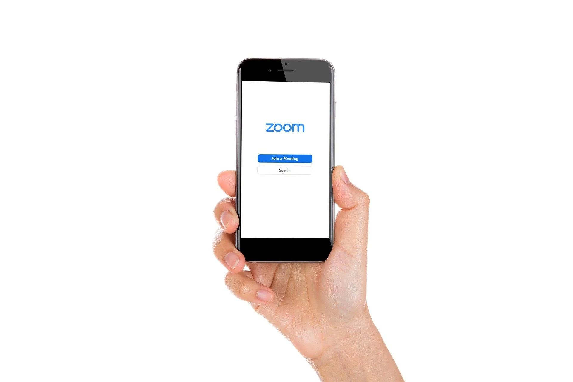 Hand holding a smartphone displaying the Zoom app login screen with options to join a meeting or sign in.