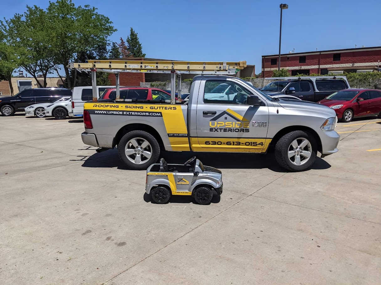 Upside Exteriors work truck with a matching miniature truck parked beside it.