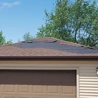 Garage roof with missing and damaged shingles before repair