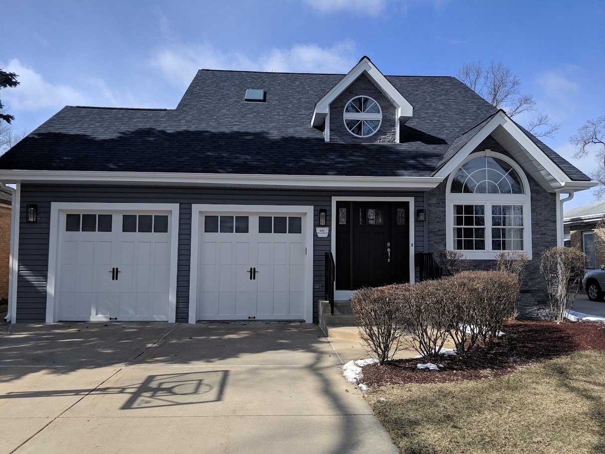 Completed dark shingle roof on a home with garage