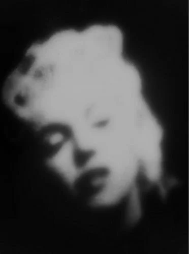 Black and white photo of a woman with platinum blonde hair and dark lipstick