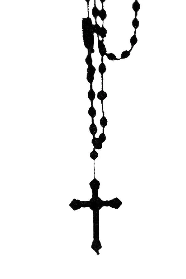 Black rosary beads with a cross pendant hanging against a white background.