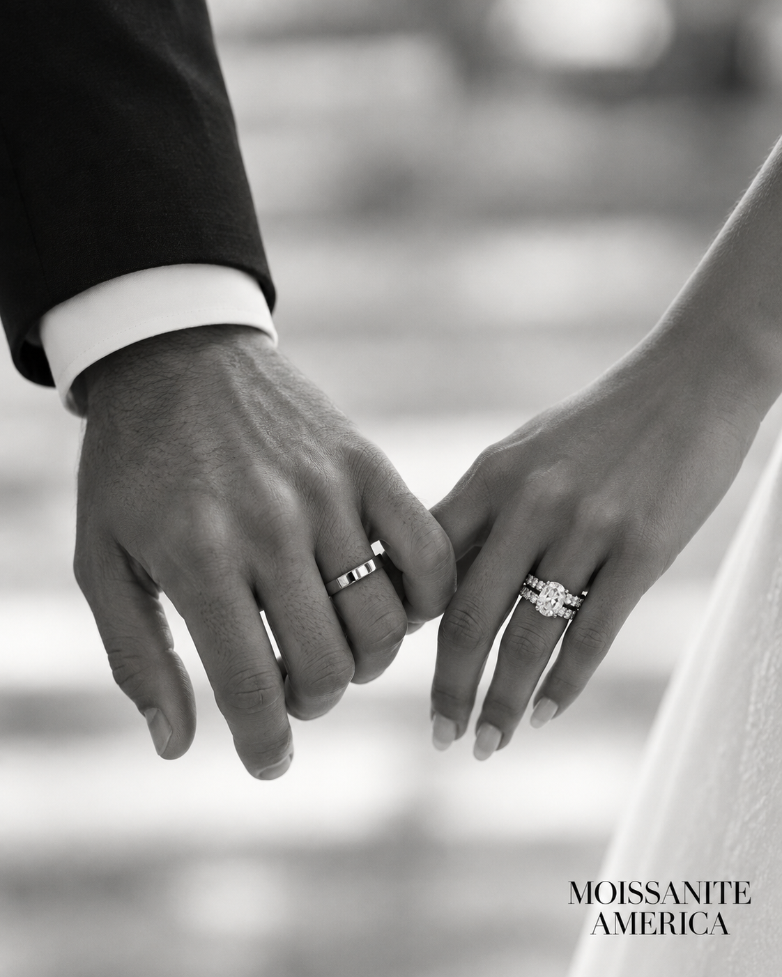 Couple holding hands wearing moissanite engagement ring and wedding bands