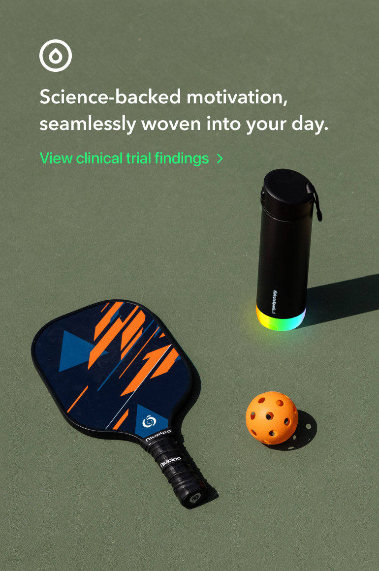 Black pickleball paddle, orange perforated ball, and glowing black water bottle on a green court with motivational text.