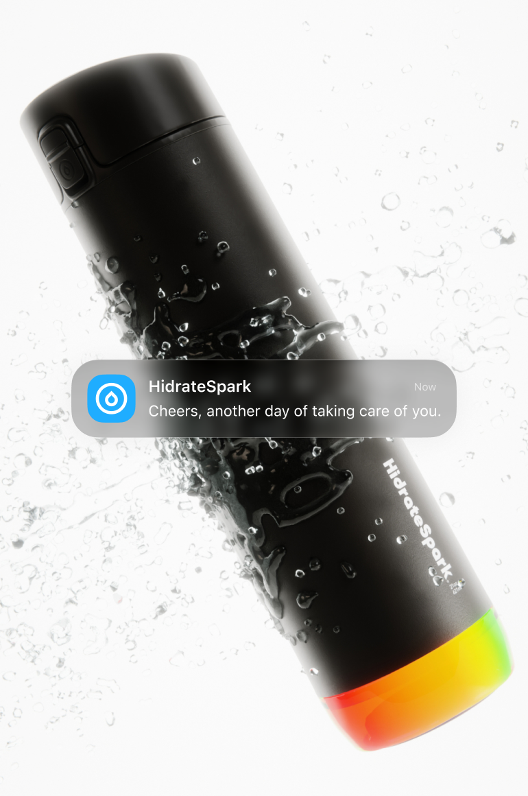 Black HidrateSpark smart water bottle splashing through water with a hydration reminder notification