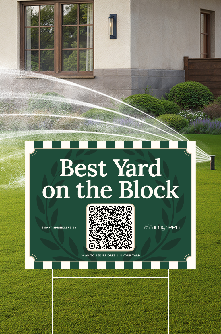 Lawn sprinkler system watering a landscaped yard beside a house, with a sign reading “Best Yard on the Block” and an Irrigreen QR code.
