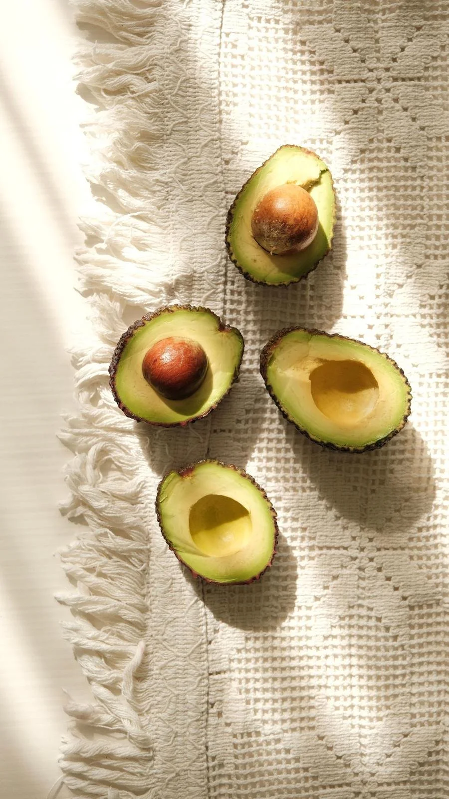 Avocado halves on a woven linen cloth