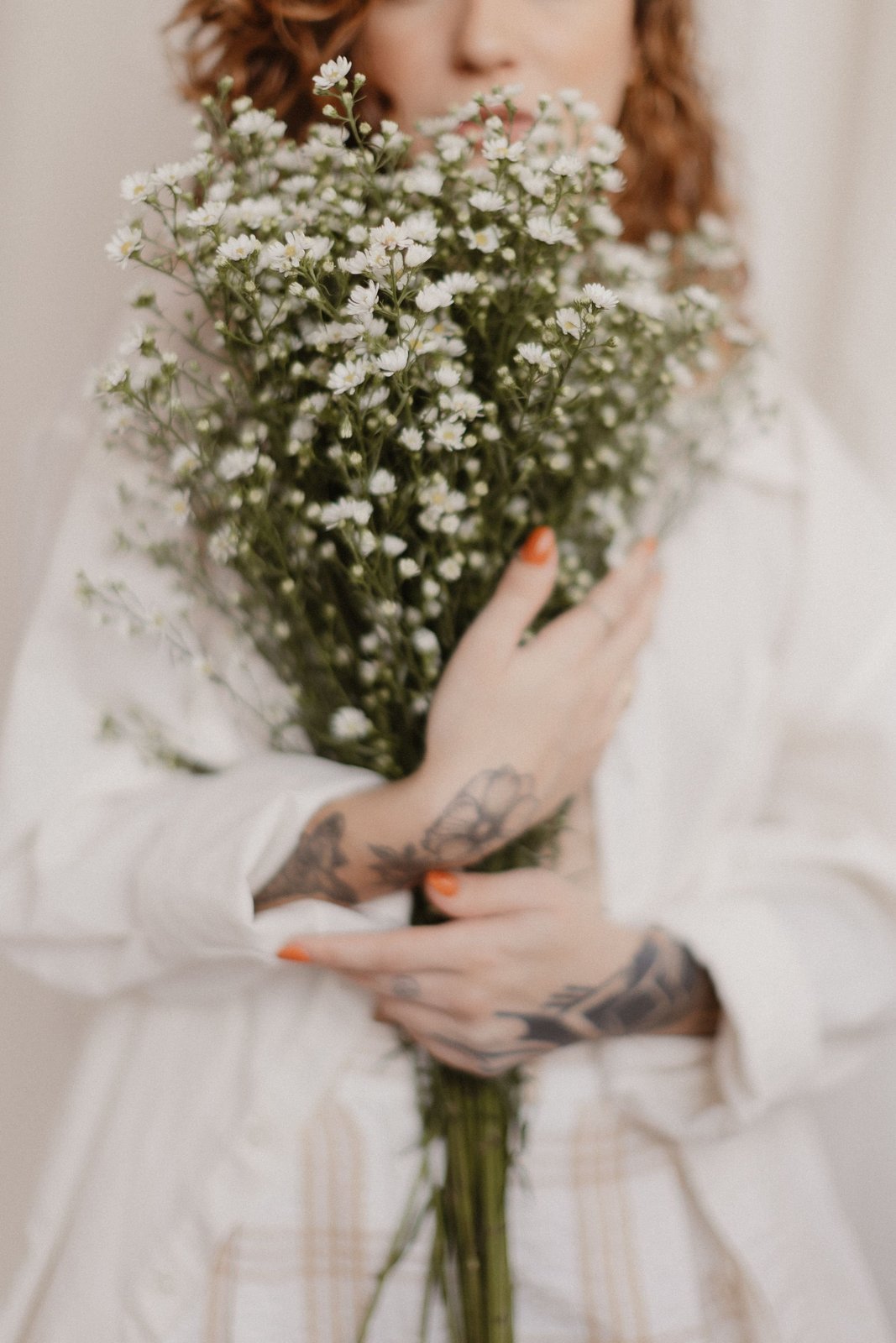 Woman holding a bouquet of white wildflowers, a reminder that feeling good in your body doesn't require dieting