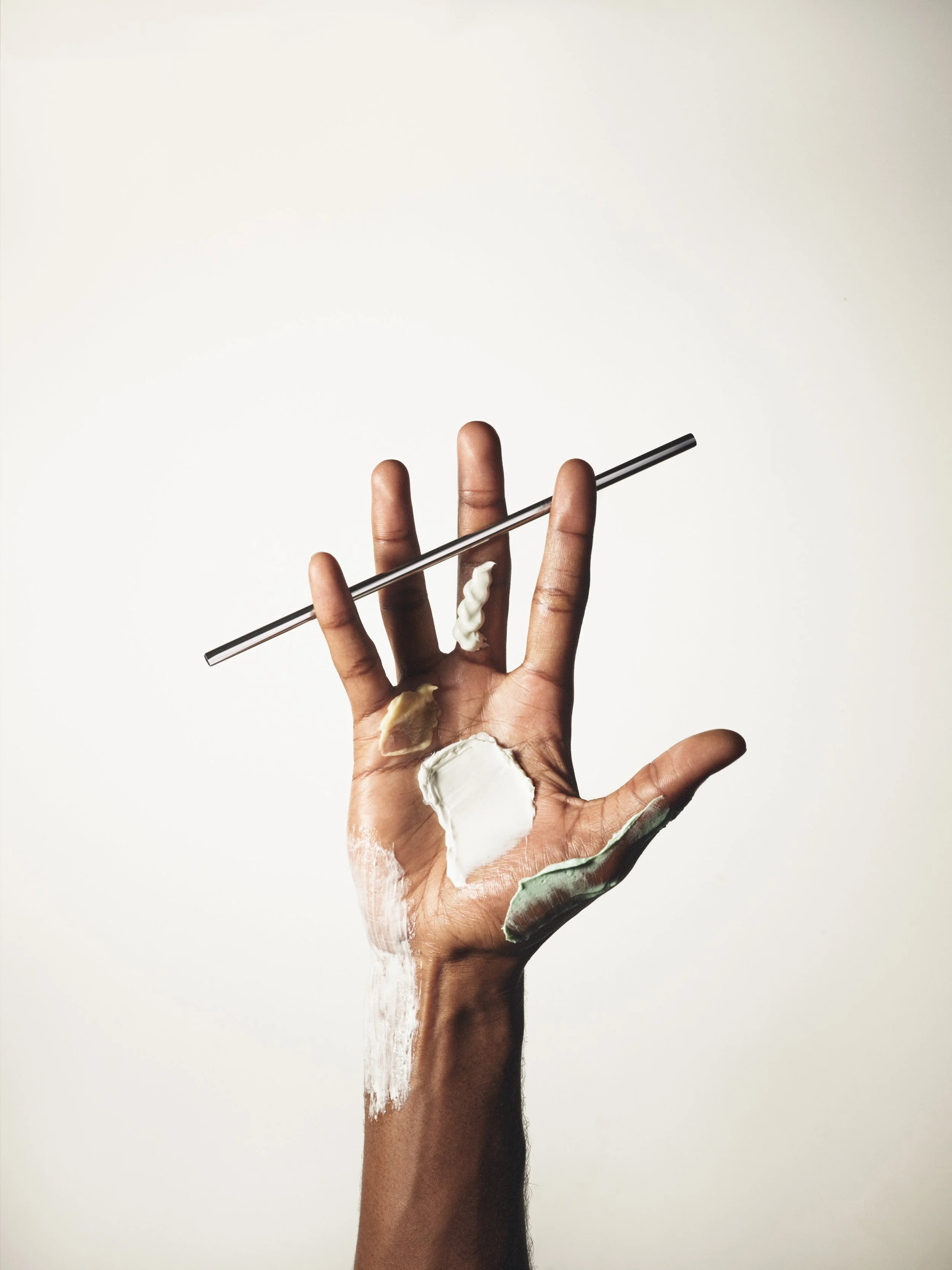 Hand mit verschiedenen Cremes und Seren.