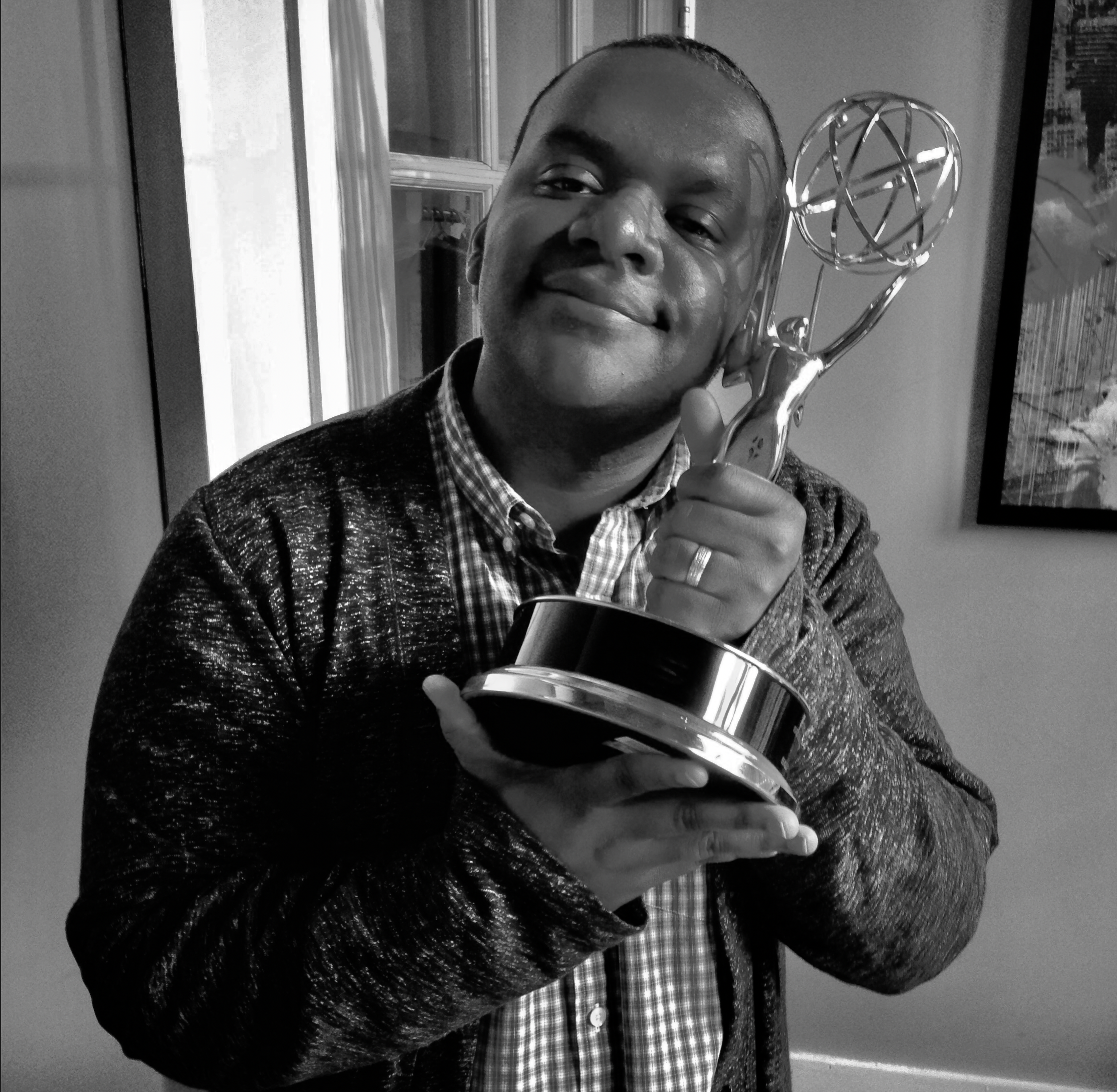 Sean smiling holding an Emmy award.