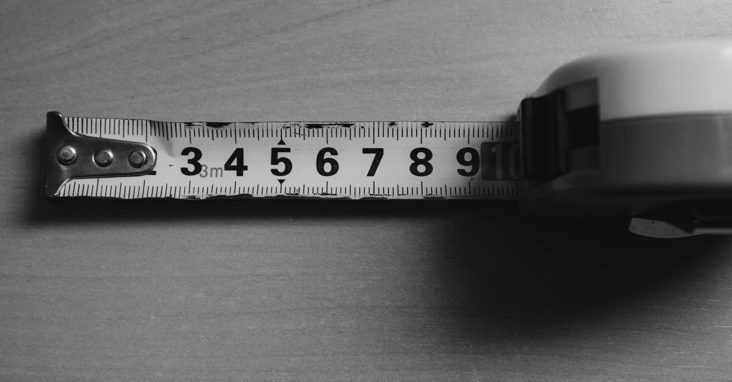 A tape measure extended to approximately 9 inches on a flat surface.