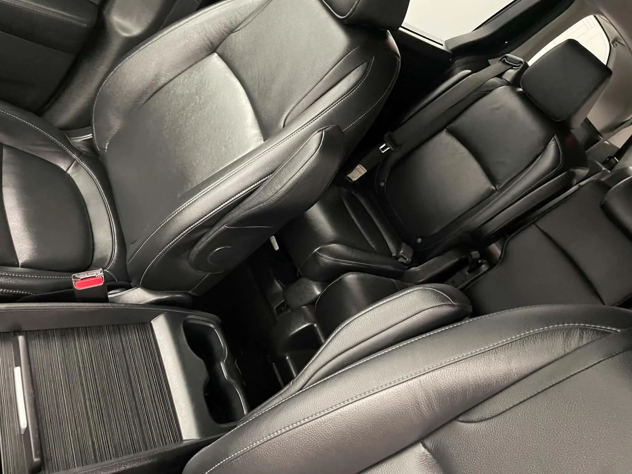 Photo of the interior of a car showing black leather seats, backrests, and headrests.