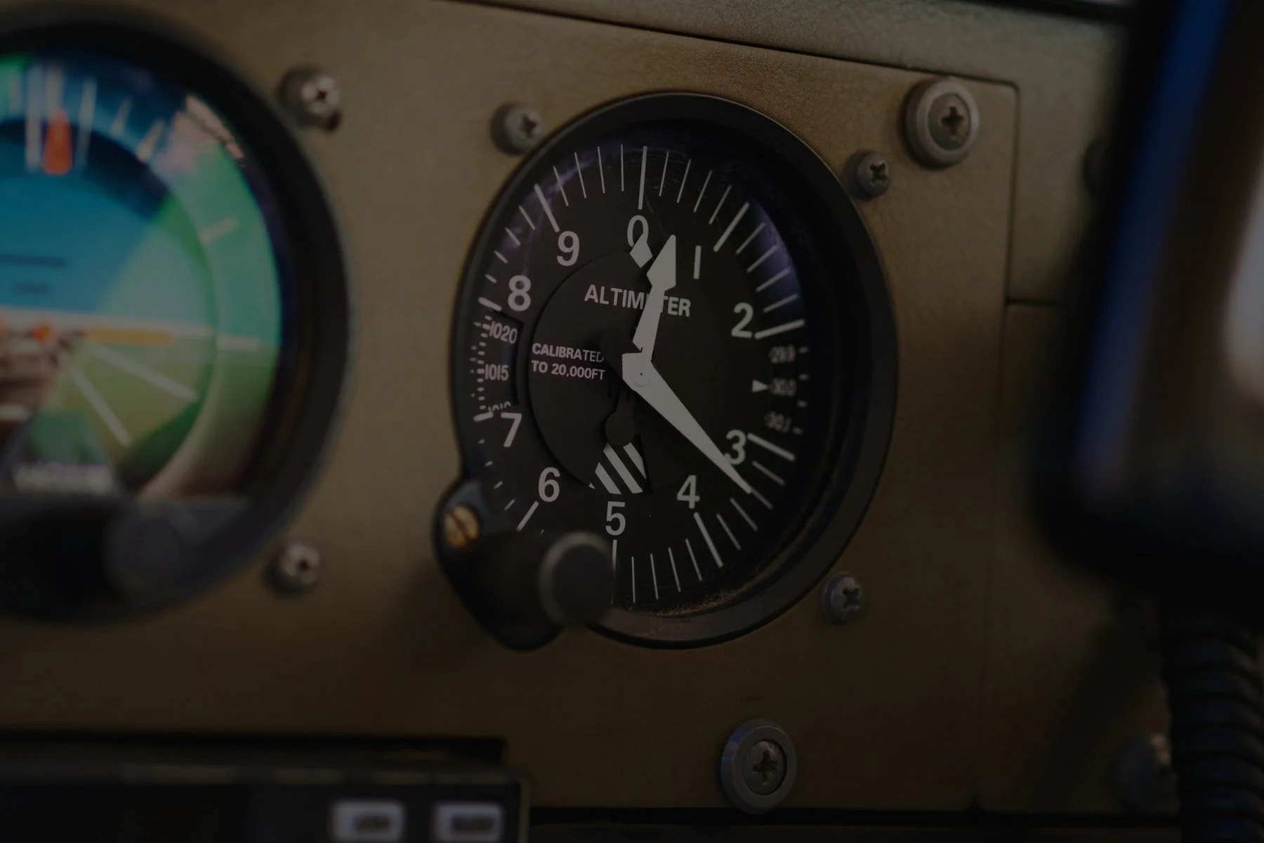Close-up of an aircraft altimeter showing approximately 1000 feet altitude.