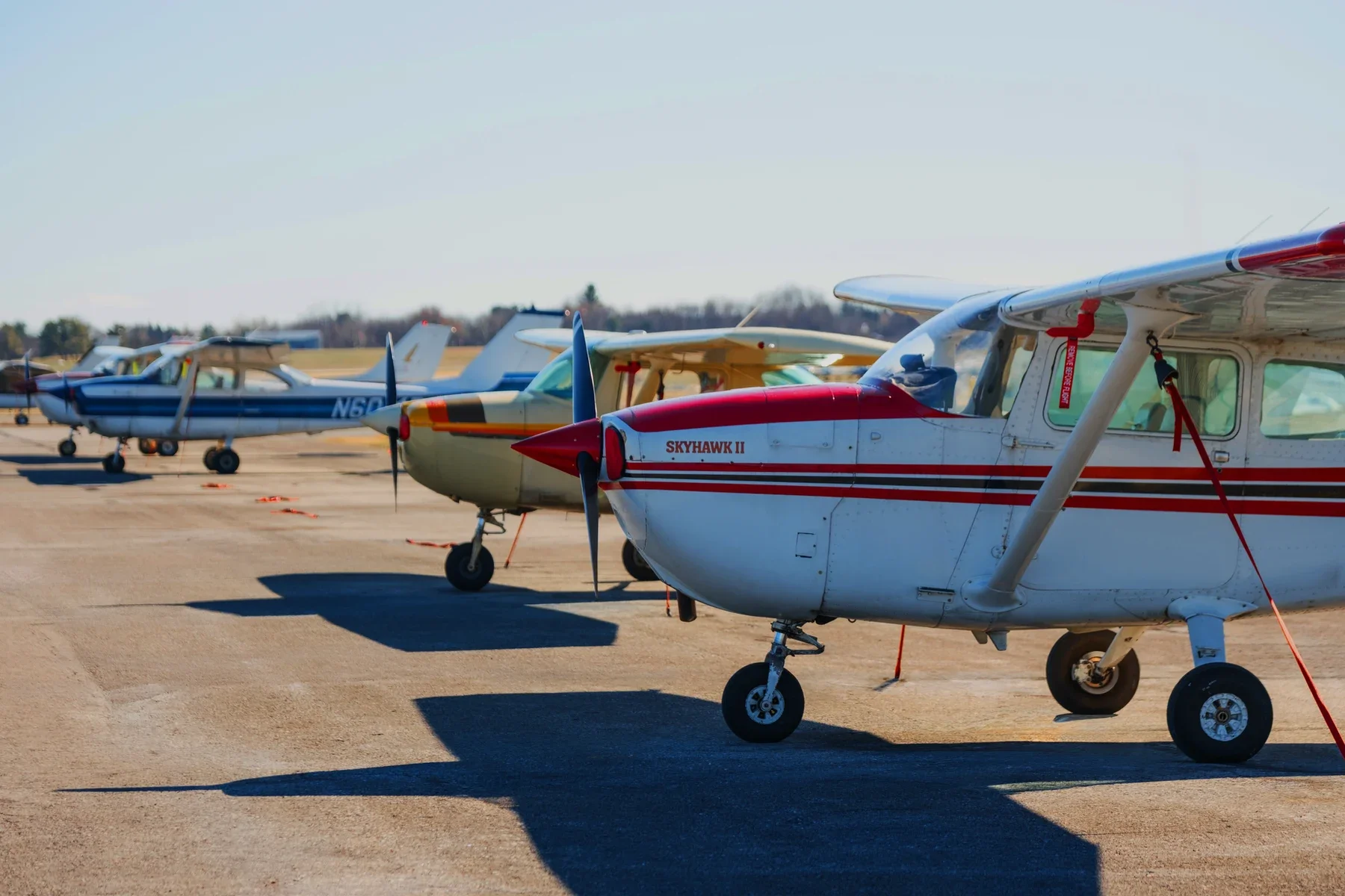 Multiple small airplanes parked on a runway, with the closest one labeled 'Skyhawk II'.