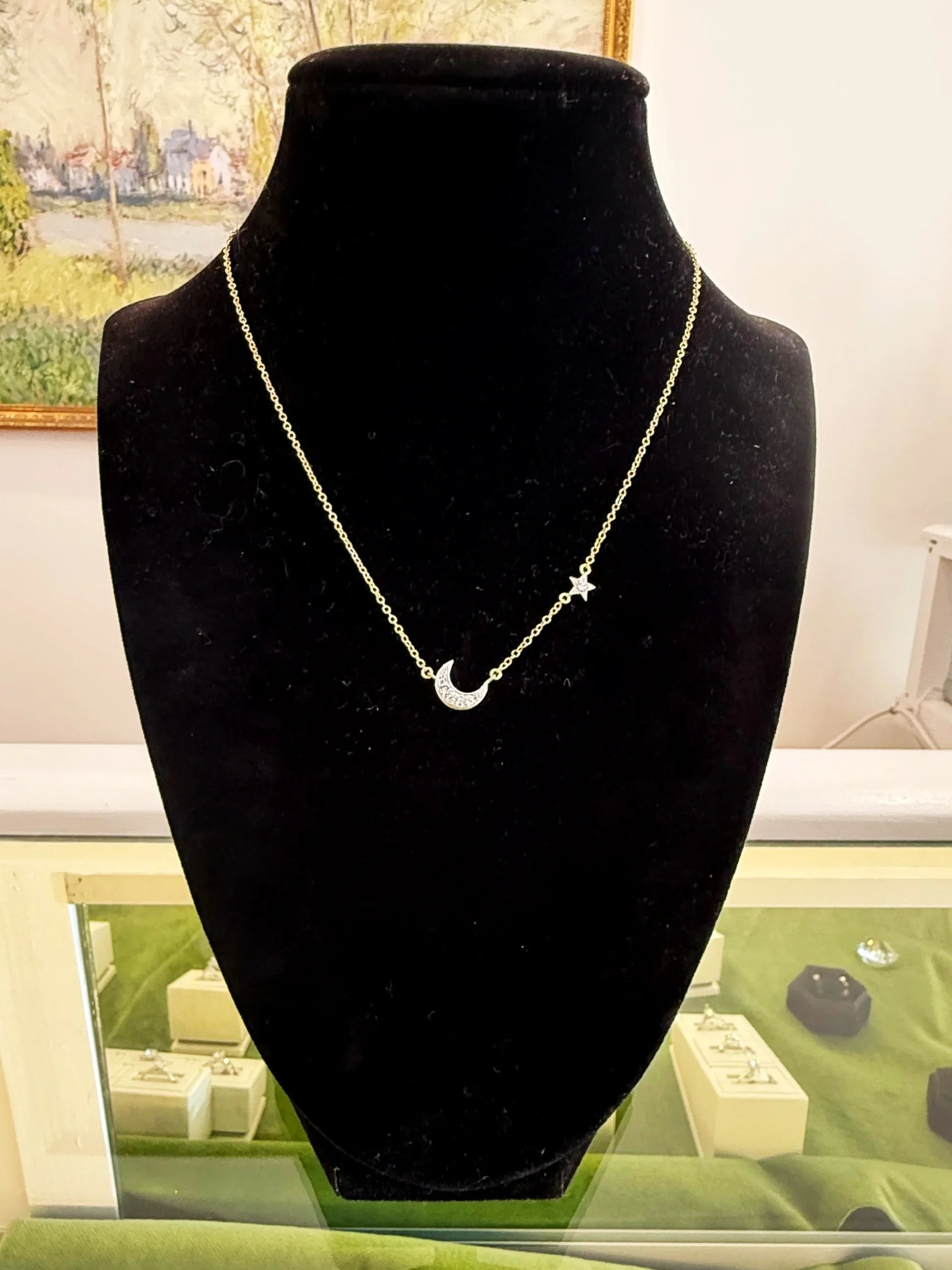 The "Wandering Star," necklace: a 14K gold chain with a 14K white gold moon and star, each set with diamonds.