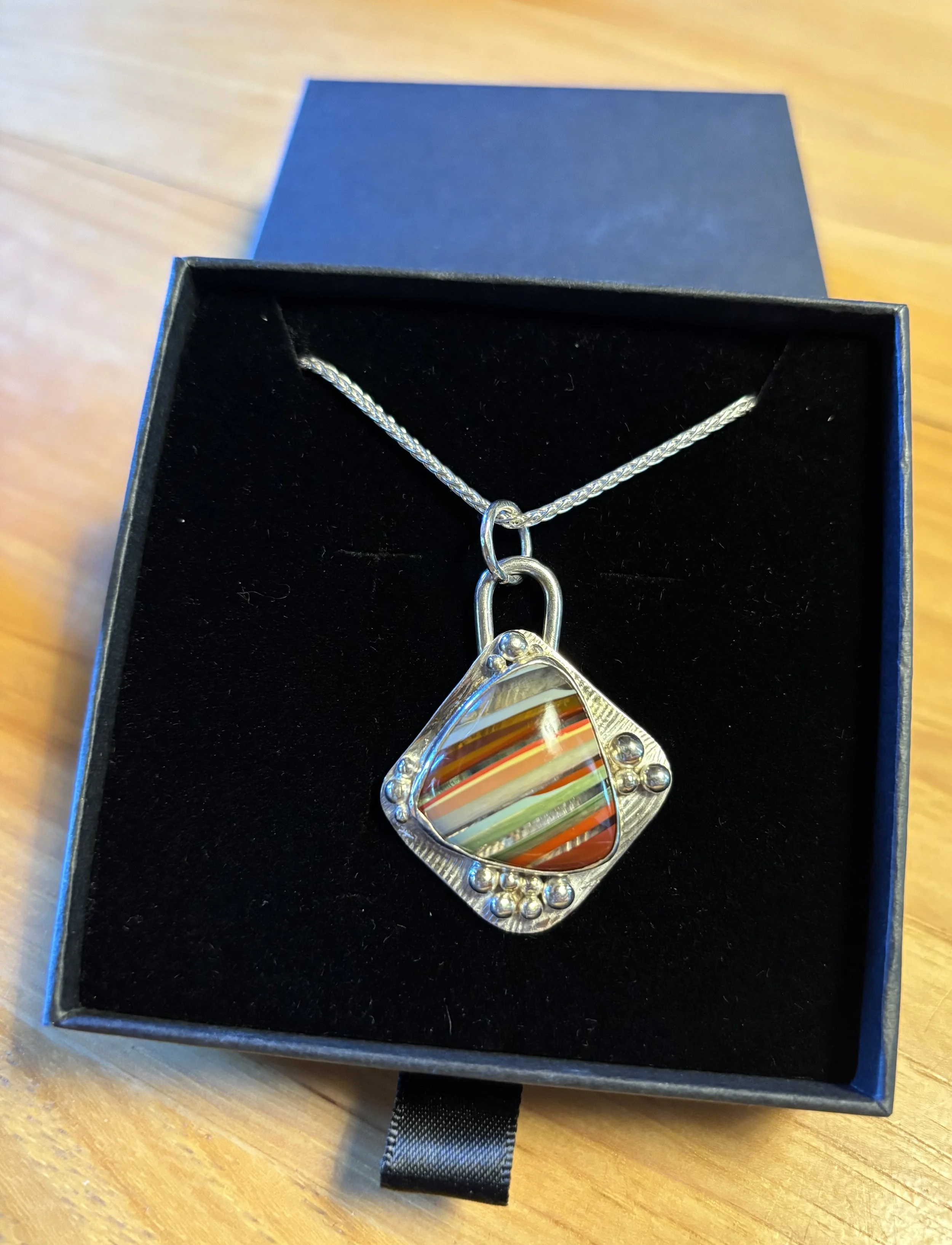 Sterling silver necklace with a surfite cabochon. Surfite is made from recycled surfboard resin. We currently have a small selection of surfite pendants and rings in the shop.