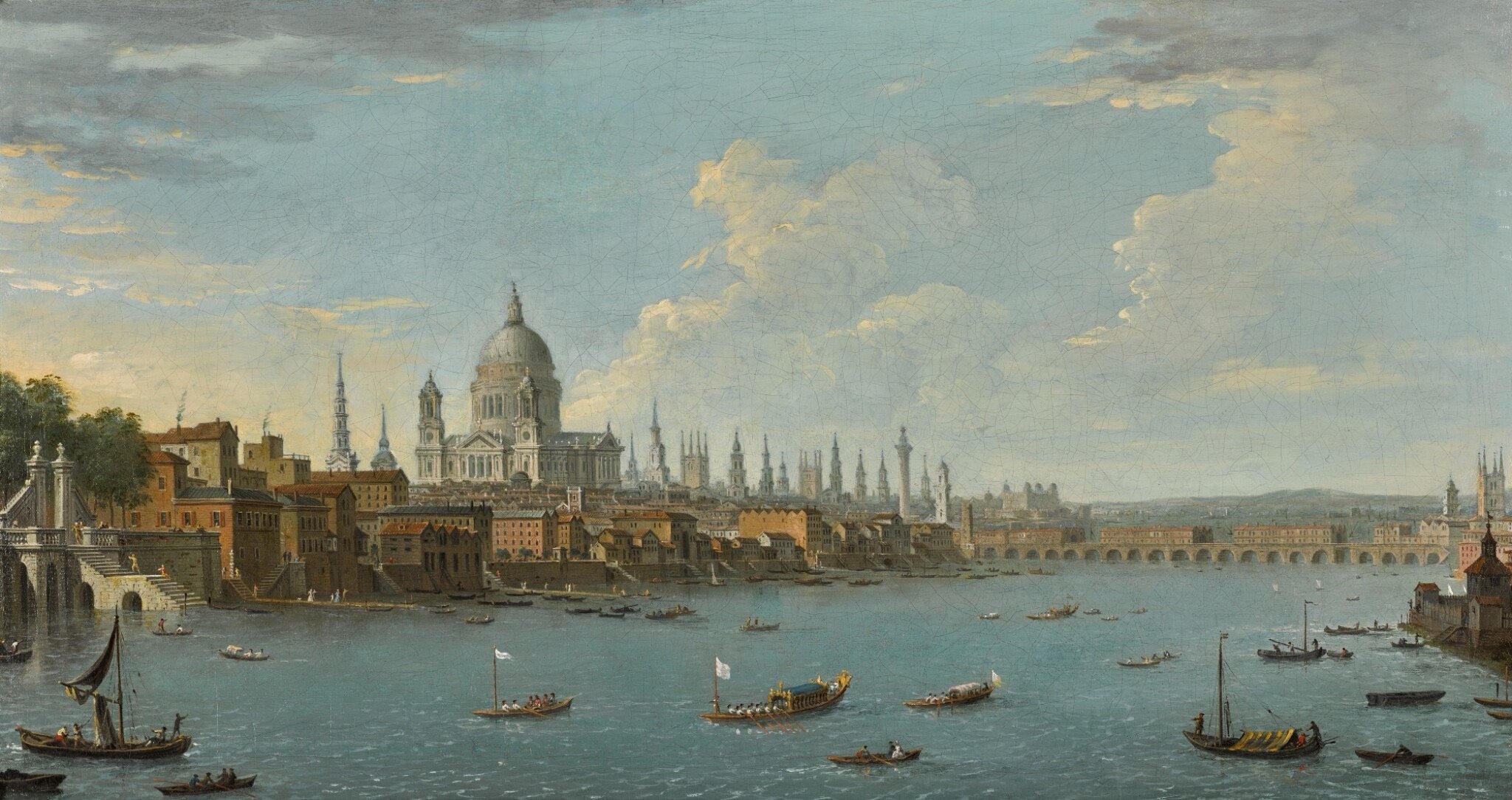 A historic painting of a cityscape along a river, featuring a large domed cathedral, numerous church spires, and buildings with red-tiled roofs. Boats are visible in the water, with a bridge in the background, under a partly cloudy sky.