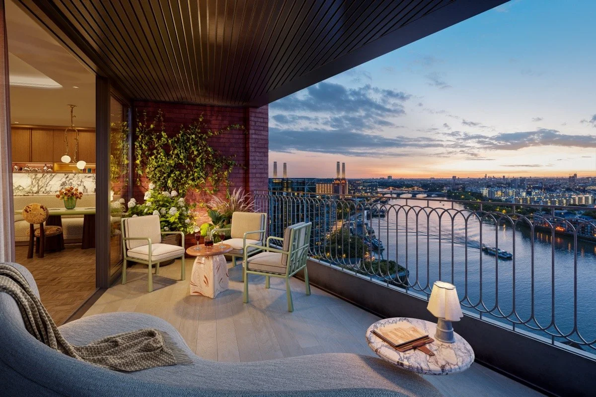 A balcony with outdoor furniture overlooking a city skyline and a river at sunset.