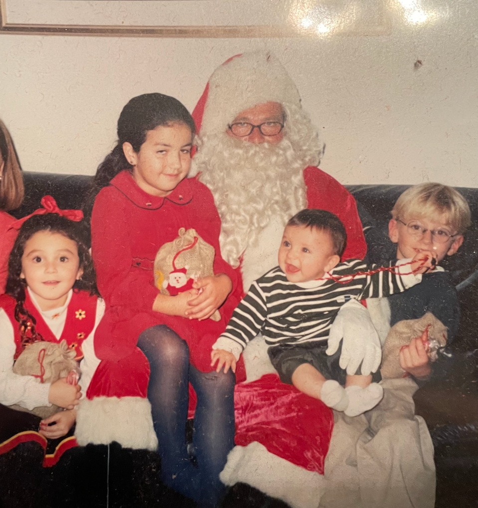 Children sitting with Santa Claus in a holiday photo.