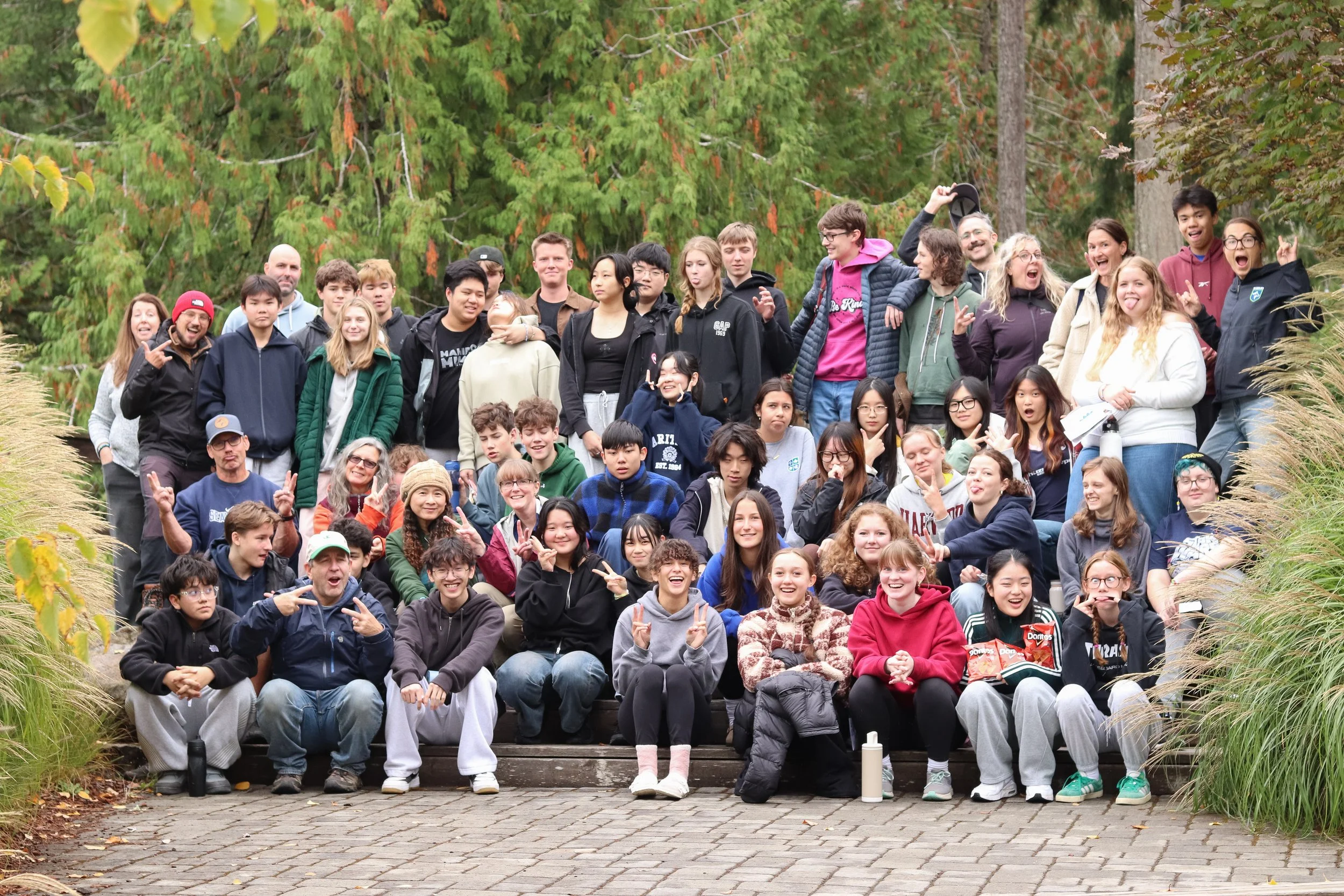 Large diverse group of students posing together on outdoor steps.